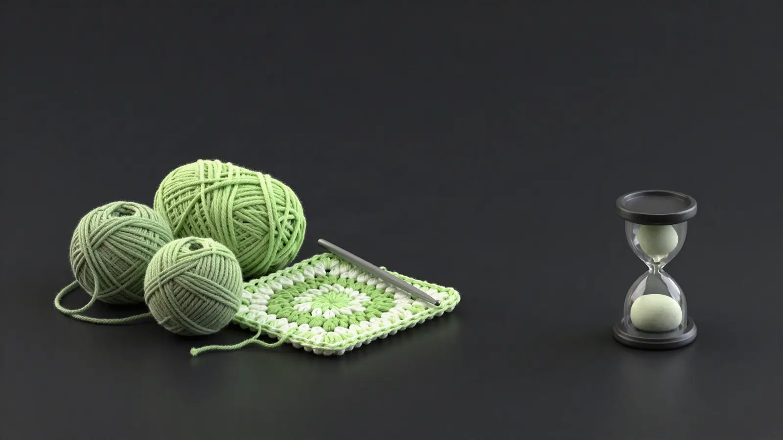 Yarn, a crochet hook and a half-finished square next to an hourglass